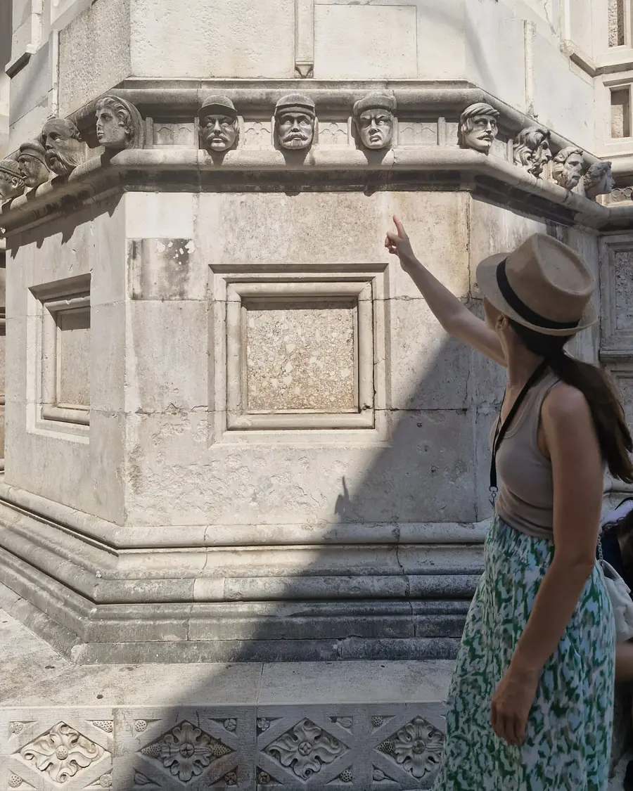 Ivana pointing out the carved stone heads on the Cathedral of St. James in Šibenik