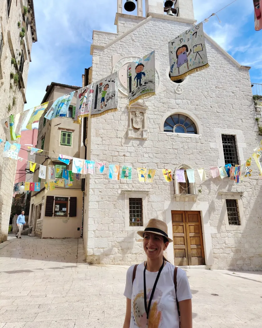 Ivana, licensed Šibenik tour guide, in front of a small stone church in the Old Town