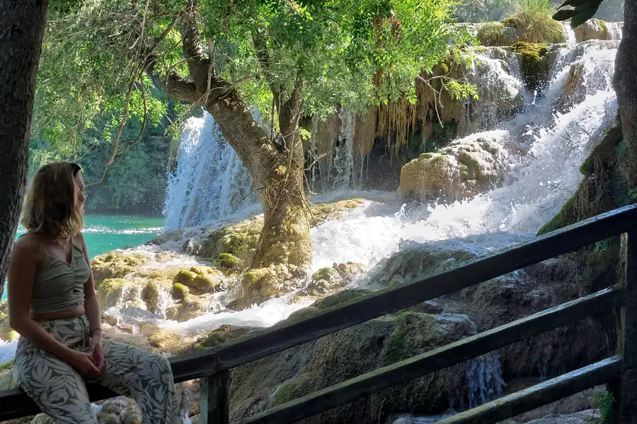 A guest resting beside a travertine cascade on the Krka National Park walking tour