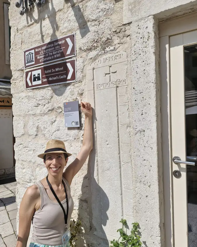 Ivana pointing out a carved stone inscription during an Old Town walking tour in Šibenik