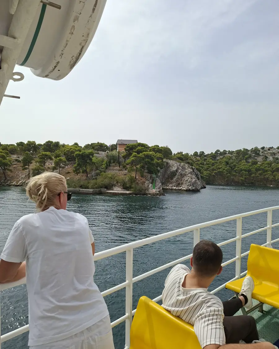 Passengers on the open deck watching the coast on the public boat to Zlarin